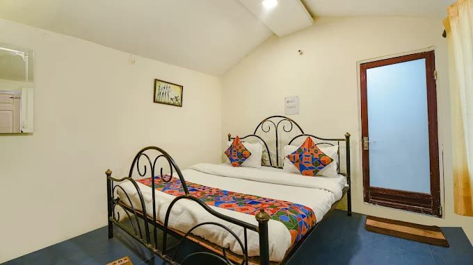 Deluxe Double Cottage Room with wrought iron bed and geometric linens