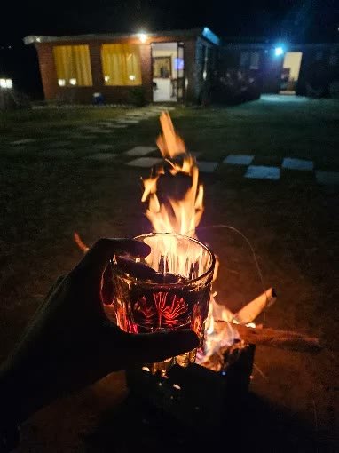Evening wood campfire pit glowing in front of cottages
