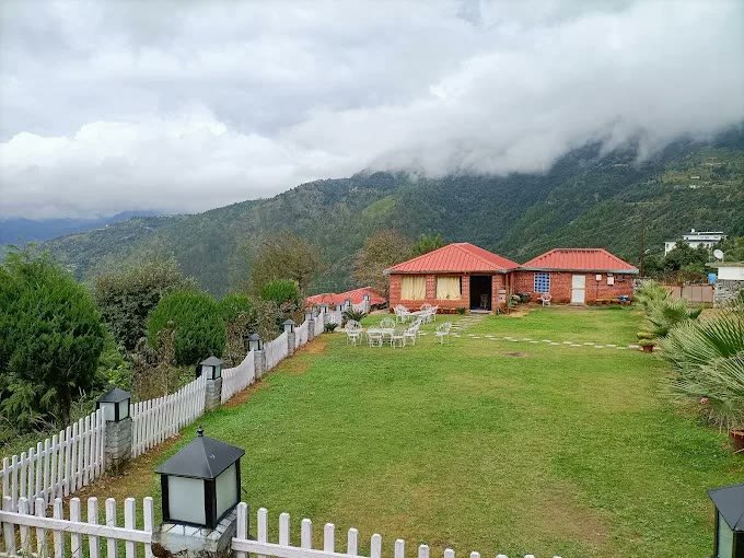 Panoramic view of mountain lawn and Himalayan valley at Kanatal Camp