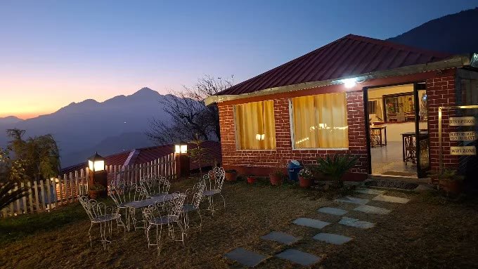 Red Roof Restaurant and lit lanterns at twilight in Kanatal