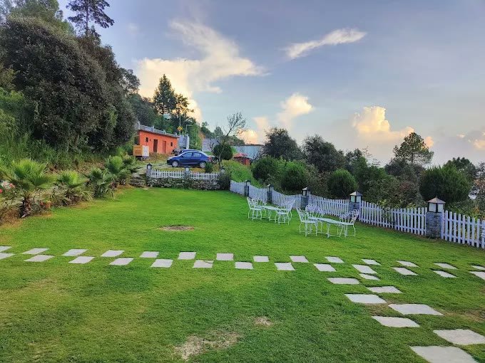Green lawn and mountain view at resort in Kanatal